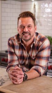 Jimmy Doherty smiling next to his kitchen counter